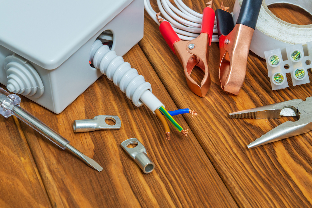 Electrical repair tools on wooden desk.