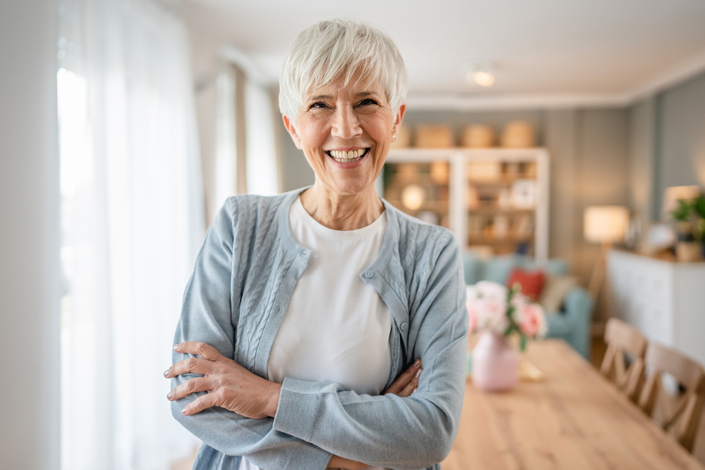 Portrait photo of happy woman smiling into camera thanks to electrical repair.