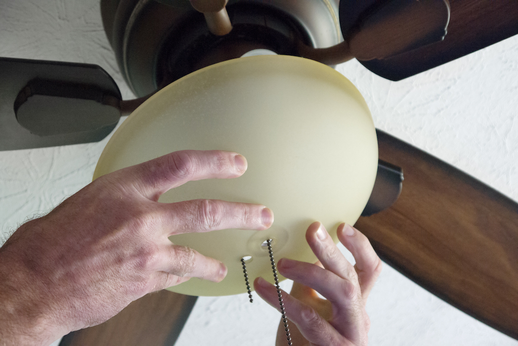Ceiling fan installation with two hands. | Ceiling Fans