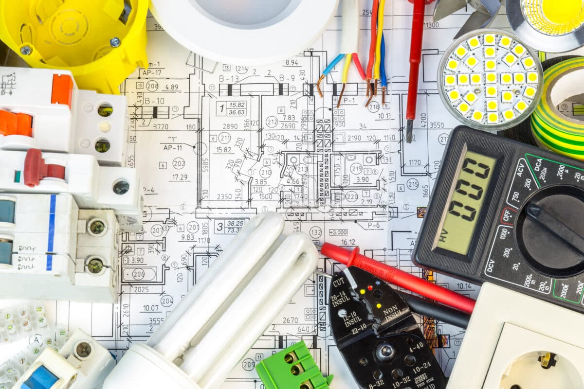 Electrical components arranged on blueprints for electrical upgrades.